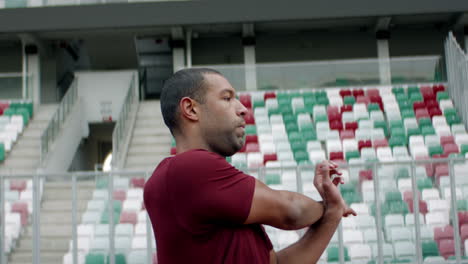 Porträt-Eines-Afroamerikanischen-Schwarzen-Mannes,-Der-Sich-Vor-Dem-Laufen-Am-Frühen-Morgen-Auf-Einer-Leeren-Stadionstrecke-Aufwärmt.-Aufgenommen-Mit-Anamorphotischem-Objektiv